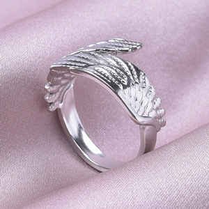 Macro shot of silver angel wing ring texture on premium purple satin fabric