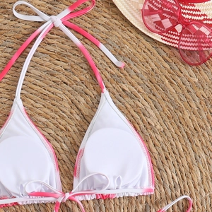 Flat lay of tie-neck bikini top with pink tie-dye pattern on woven mat with sunglasses