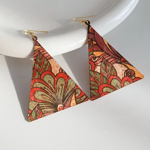 Detailed close-up of triangular leather earrings with colorful ethnic floral patterns