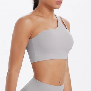 Detail of light grey one-shoulder sports bra with seamless nylon brushed texture