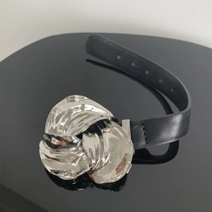 Detail van een zwarte lederen armband met een grote zilveren metalen bloemvormige gesp