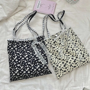 Detail of floral canvas tote bags with delicate lace trim and daisy woven shoulder straps