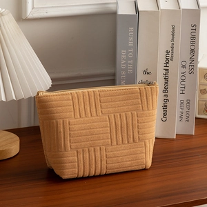 Detail of ginger striped makeup bag texture and zipper on a rustic wooden table