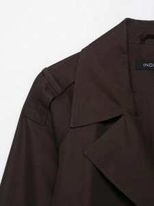 Close-up of shoulder epaulets and lapel details on a dark brown cropped trench jacket