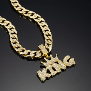 Macro shot of gold-plated iced-out KING crown pendant with rhinestone Cuban chain link
