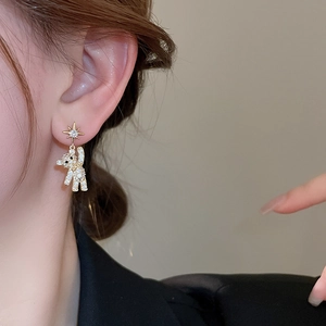 Chic gold earrings with micro-inlaid rhinestone bear and star studs on a model