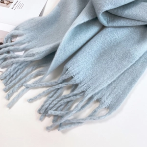Close-up of light blue mohair scarf with fringe detail showing soft fuzzy texture