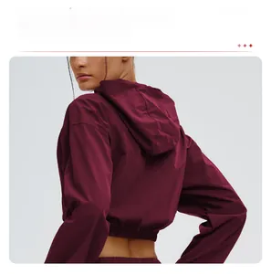 Detail of burgundy windproof hooded jacket showing elastic waist and back design