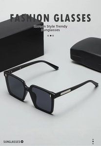 Detail of square black sunglasses with gold metal bar accents on the frame temples