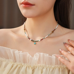 Detailed view of turquoise pendant pearl necklace with multi-color beads on model