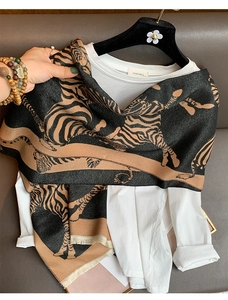 Detailed view of the tiger print scarf texture with black and brown tassels