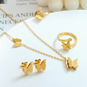 Elegant gold butterfly jewelry set featuring frosted necklace, earrings and open rings