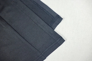 Detail shot of the precise stitching on the sleeve cuff of a slim-fit ruching dress
