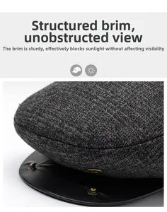 Detail of dark grey textured fabric hat with black leather brim and metal rivets