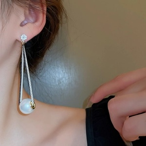 Detail of long fringe tassel earrings with white pearls and sparkling zircons on model