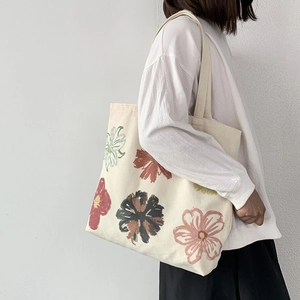 Detail view of cotton canvas tote bag featuring colorful hand-painted floral art pattern