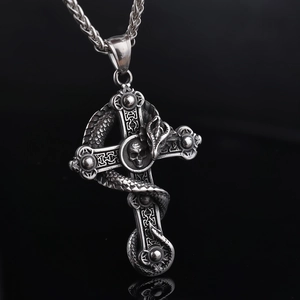 Macro detail of vintage silver skull and snake pendant on a dark gothic cross