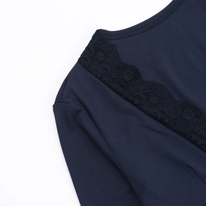 Detailed close-up of dark blue knit fabric with black floral lace trim on the V-neckline