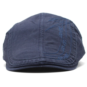 Close-up of dark blue cotton flat cap featuring detailed side embroidery and twill texture
