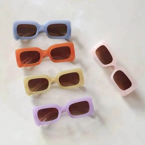 Cinque paia di occhiali da sole vintage Y2K in vari colori pastello su sfondo grigio