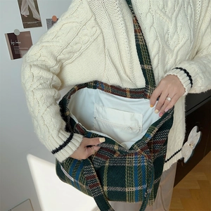 Detailed view of dark green plaid wool tote bag interior featuring a secure zipper pocket