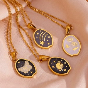 Detailed macro view of 18K gold plated oval pendants with butterfly and star motifs