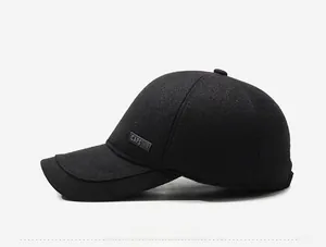 Detailed view of black winter baseball cap with side metal tag and twill texture fabric