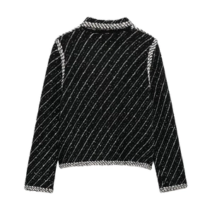 Rear view detail of black and white tweed knit jacket with classic braided trim texture