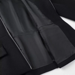 Detail of black wool coat showing smooth inner lining and durable silver metal zipper