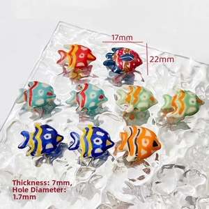 Detail of colorful hand-painted fish ceramic beads with size dimensions 22x17mm