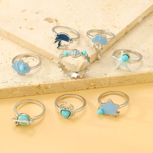 Détail de 8 bagues argentées sur le thème marin avec coquillages en émail bleu