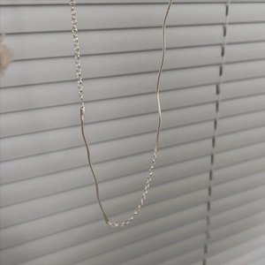 Detailed view of 925 sterling silver necklace with irregular wavy lines on a chain