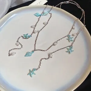 Collier bohème avec étoiles de mer bleues, coquillages et perles sur chaîne argent