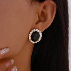Close-up of luxury oval stud earrings with black faceted crystal and sparkling rhinestones