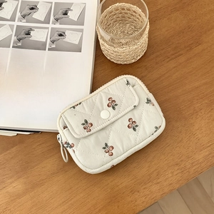 Detailed view of quilted cotton card pouch with cherry pattern and secure button flap