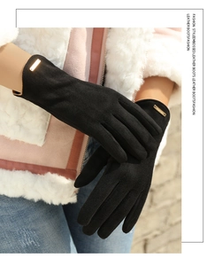 Close-up of black suede gloves with a gold metal plate and warm fleece lining for winter