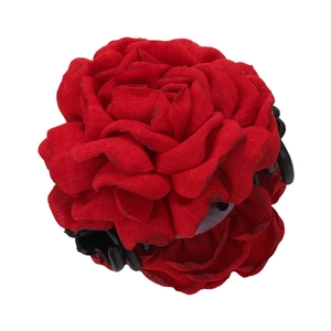 Detail of red fabric rose hair claw clip with multi-layered petals and black shark grip