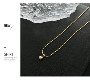 Detailed macro view of a gold titanium necklace featuring a lustrous purple pearl pendant