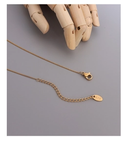 Detailed macro view of 18K gold plated necklace clasp and extender chain with K18 tag