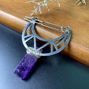 Detail of silver crescent moon hair clip with purple crystal pendant and wire wrapping