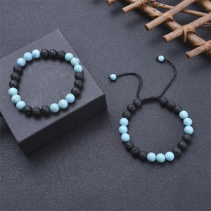 Perlenarmband Set mit Tigerauge und Lavastein auf schwarzem Geschenkkarton Hintergrund