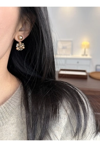 Close-up of geometric floral pearl earrings with crystals on a female model