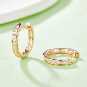 Macro shot of rose gold hoop earrings featuring elegant channel-set moissanite stones