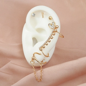 Detailed view of 7-piece gold earring set with zircon heart and tassel chain on model