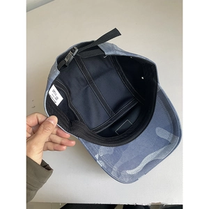 Internal view of five-panel camo baseball cap showing sweatband and adjustable buckle