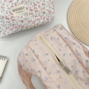 Detailed view of floral canvas lunch bags with golden zippers and fabric labels