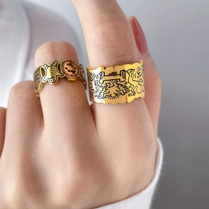 Macro shot of gold doodle rings featuring gingerbread man and Keith Haring style etching