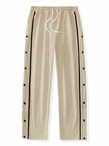 Detail of khaki jogger pants featuring black side stripes and metal snap button closures