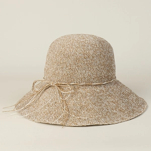 Detail of the woven paper straw sun hat with a delicate bow and textured mixed beige weave
