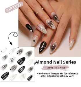 Détail de faux ongles en amande avec dégradé noir, étoiles argentées et nœuds 3D